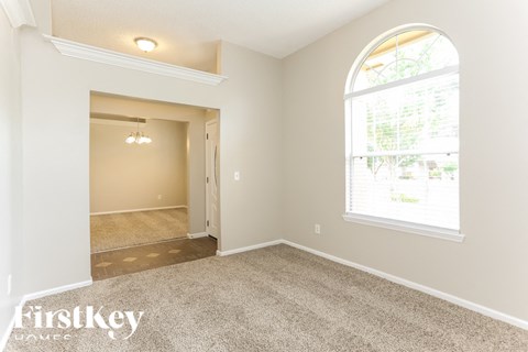 A room with a carpeted floor and a large window.