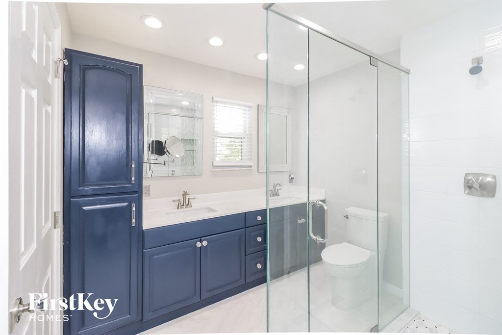 a blue and white bathroom with a shower and sink