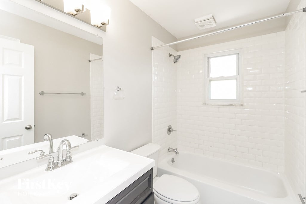a white bathroom with a tub and a sink and a toilet