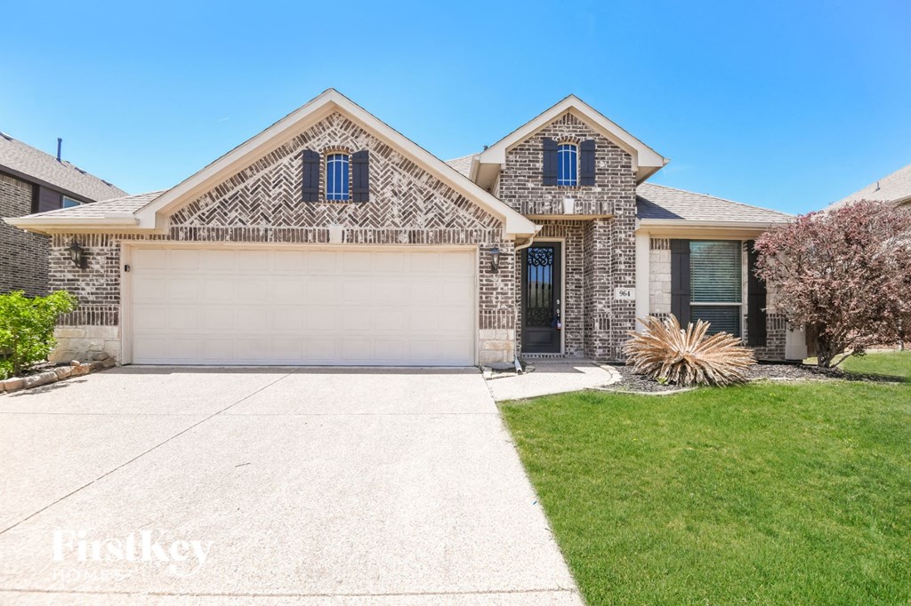 a home with a white garage door and a lawn