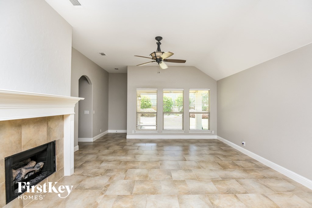 a living room with a fireplace and a ceiling fan