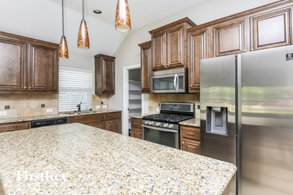 an updated kitchen with granite countertops and stainless steel appliances