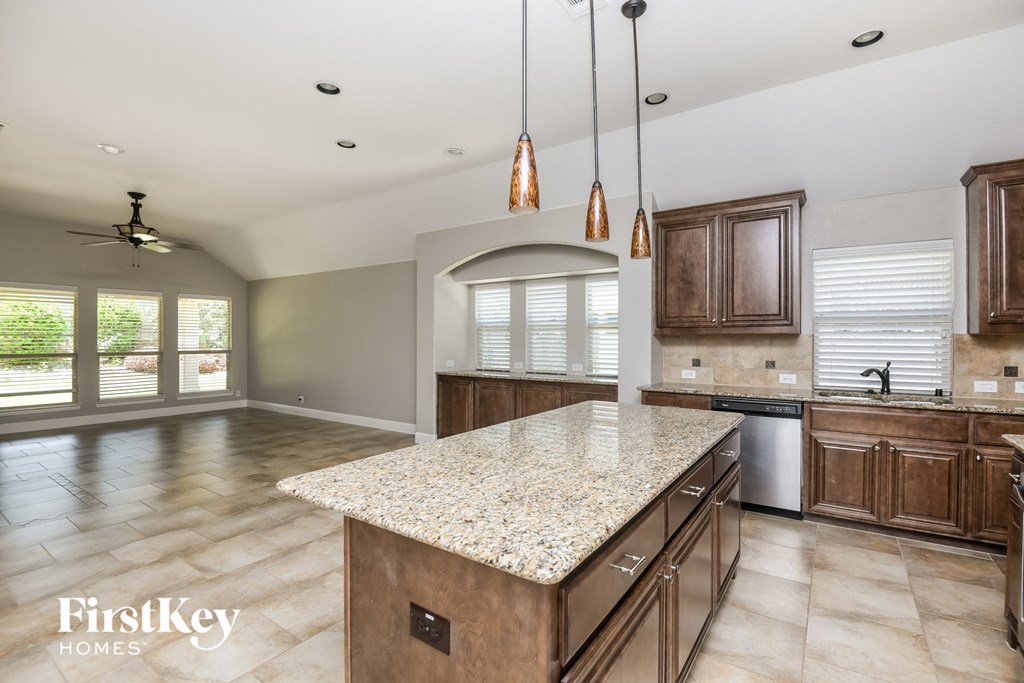 a kitchen with a marble counter top and wooden cabinets