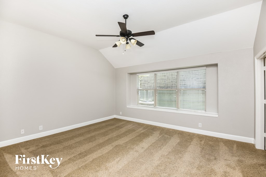 a bedroom with a ceiling fan and a window