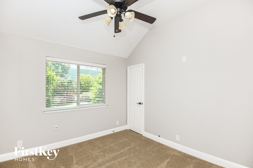 the living room of a home with a ceiling fan and a window