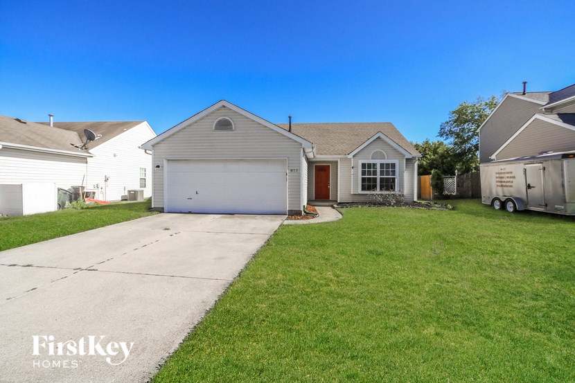 a white house with a garage and a lawn