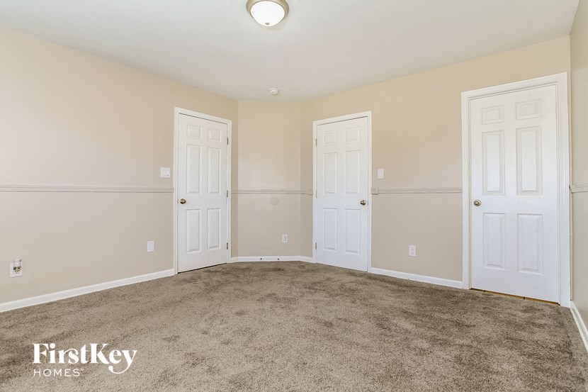 a bedroom with two doors and a carpeted floor