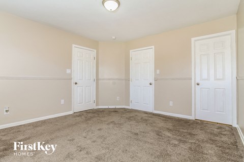 a bedroom with two doors and a carpeted floor