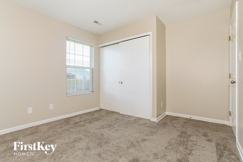 a room with carpet and a door to a closet