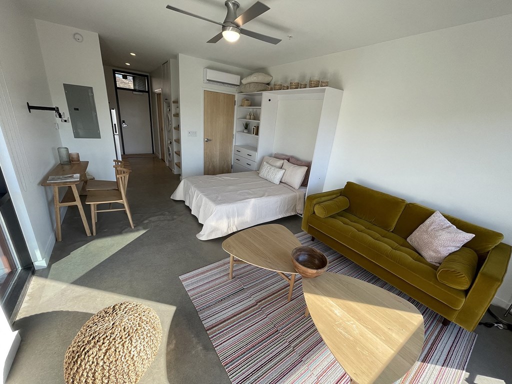 a living room with a couch and a table and a bed