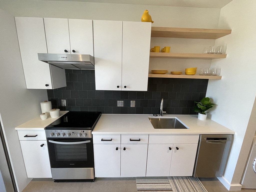 a small kitchen with white cabinets and black and white appliances