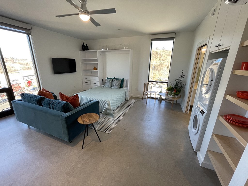 a living room with a couch and a bed and a washing machine