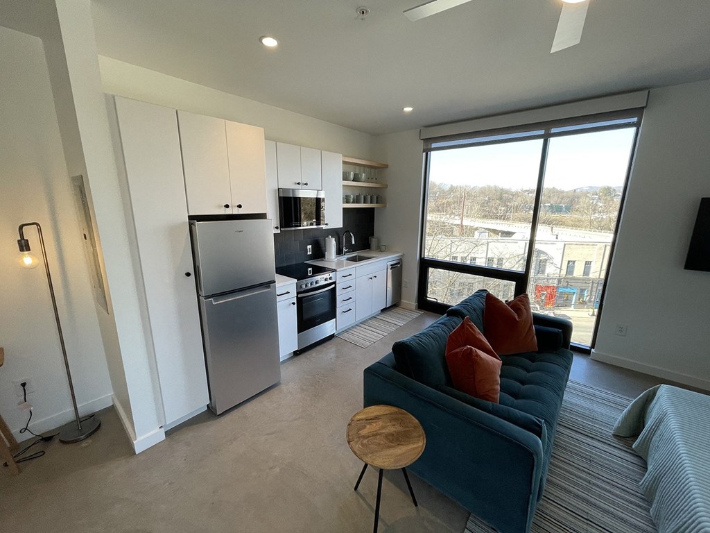 a living room with a blue couch and a kitchen