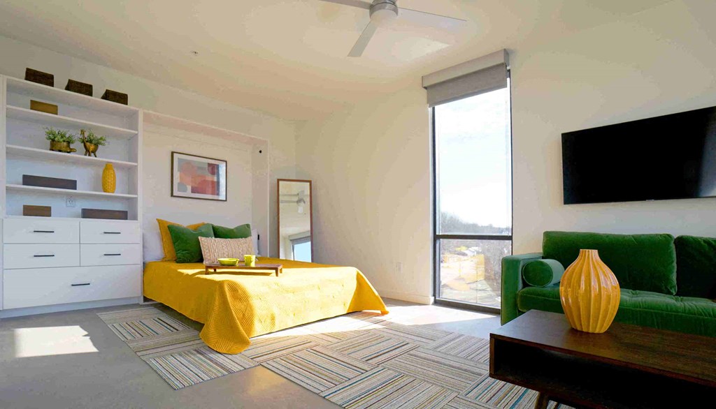 a bedroom with a yellow bed and a green couch