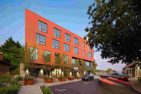 A red building with a car parked in front of it.