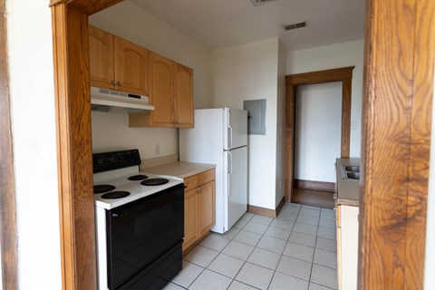 A kitchen with a black stove top oven and a white refrigerator.