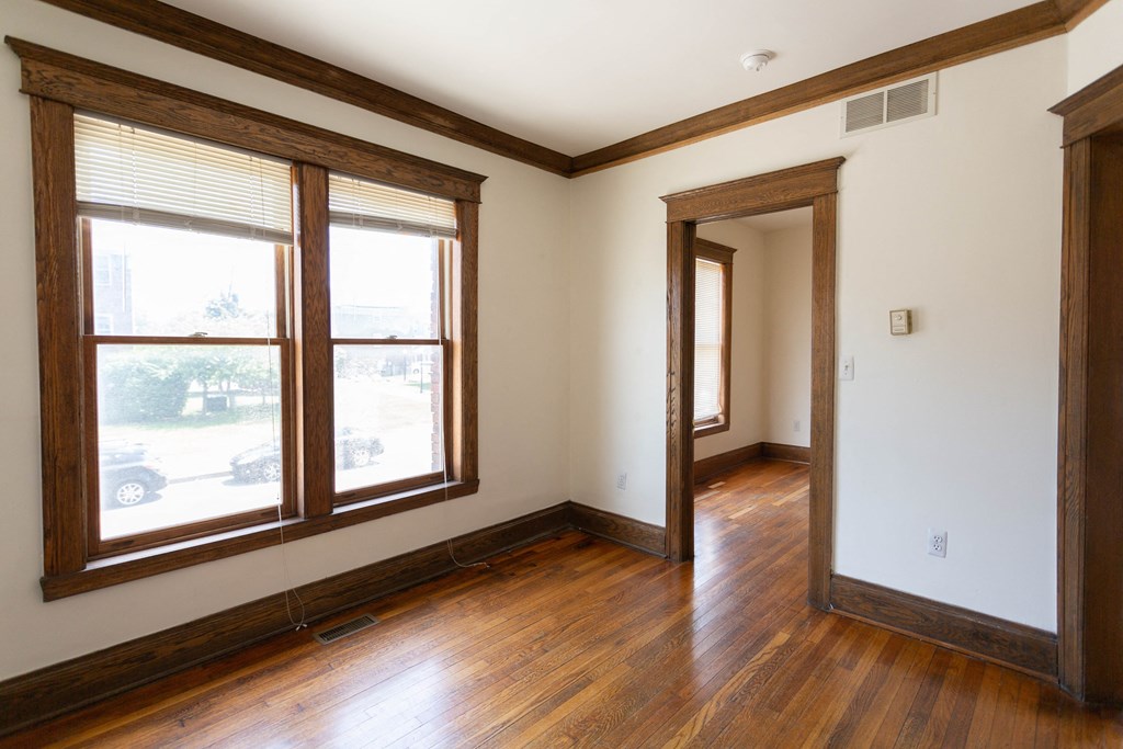 a living room with wood floors and large windows