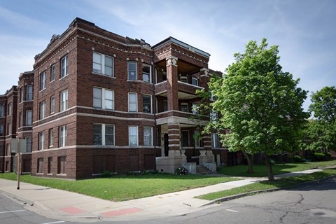 A large red brick building with a tree in front of it.