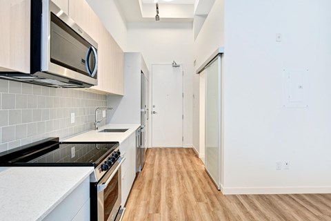 A kitchen with white cabinets and a black stove top oven.