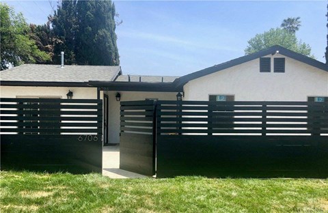 A white building with black shutters and a black door with the number 67006 on it.