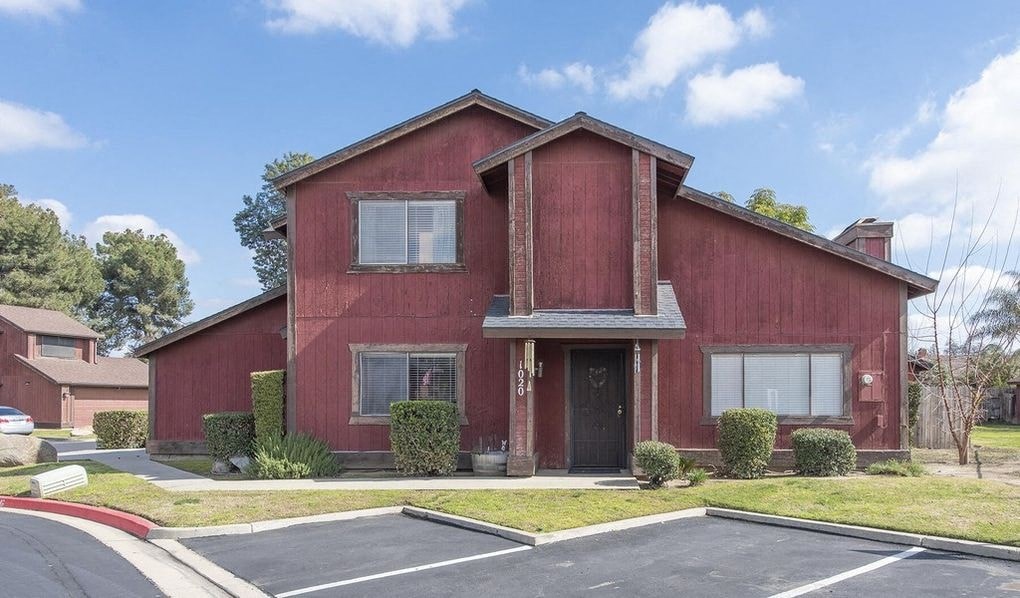 a red house with a parking lot in front of it