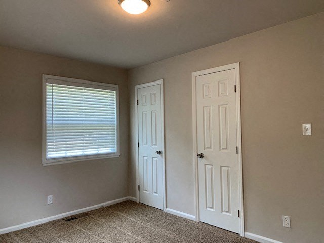 an empty room with a white door and a window