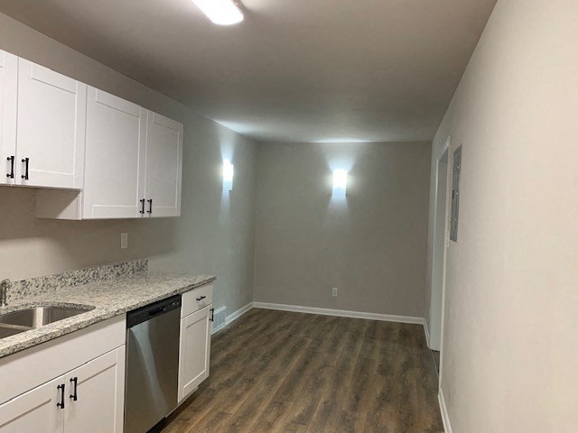 an empty kitchen with white cabinets and a sink