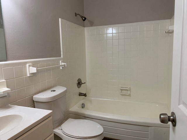 a bathroom with a toilet and a tub and a sink