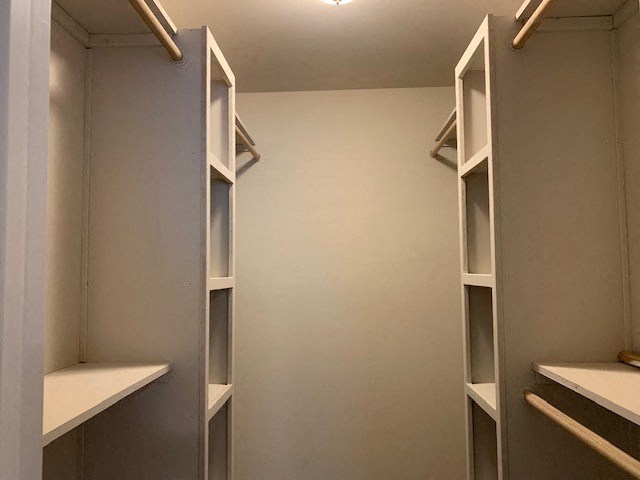 a walk in closet with empty shelves