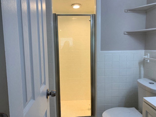 a white bathroom with a shower and a toilet