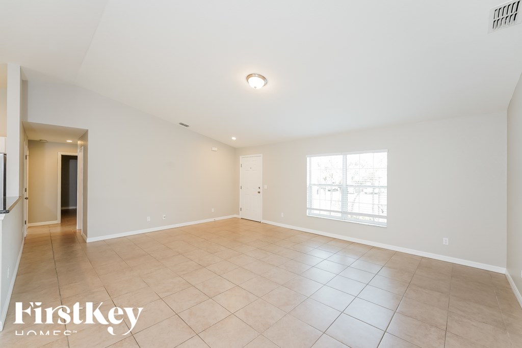 A spacious room with a tiled floor and a window letting in natural light.