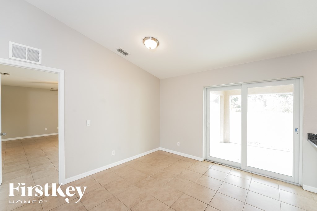 A room with a sliding glass door and a tiled floor.