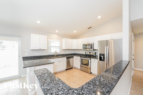 A kitchen with granite countertops and stainless steel appliances.