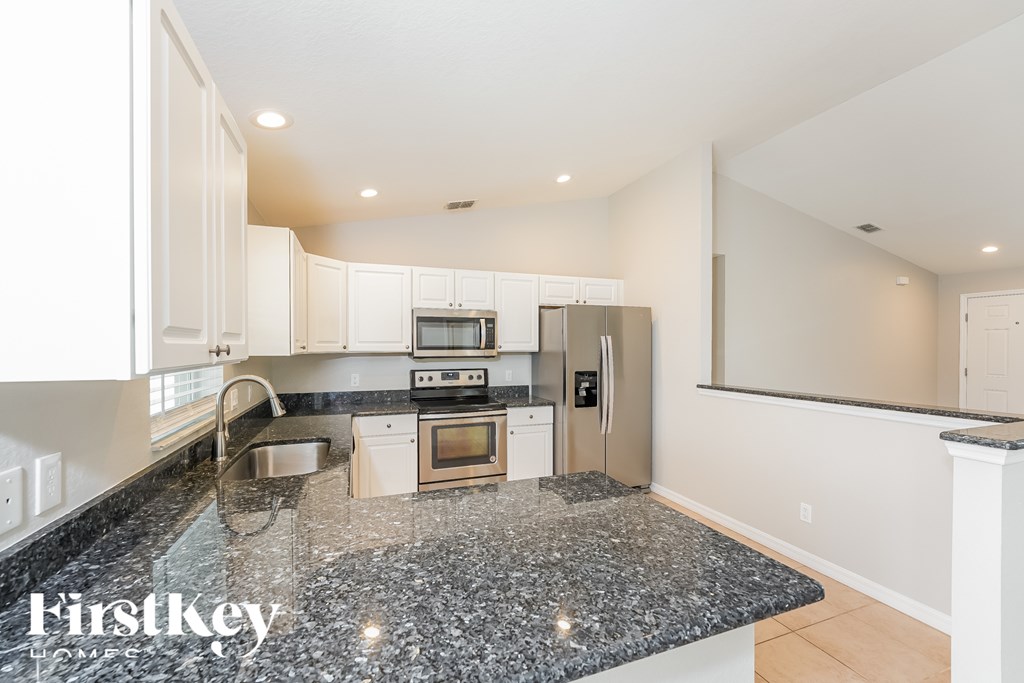 A kitchen with granite countertops and stainless steel appliances.