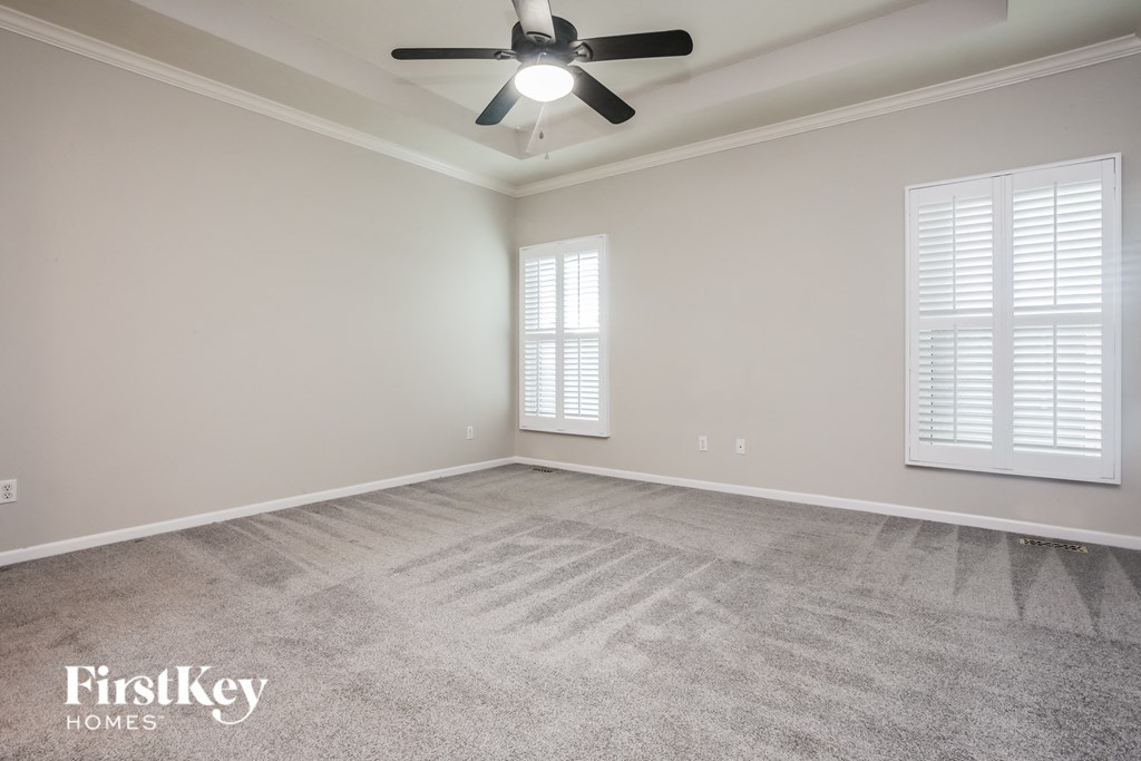 the living room of an empty house with a ceiling fan