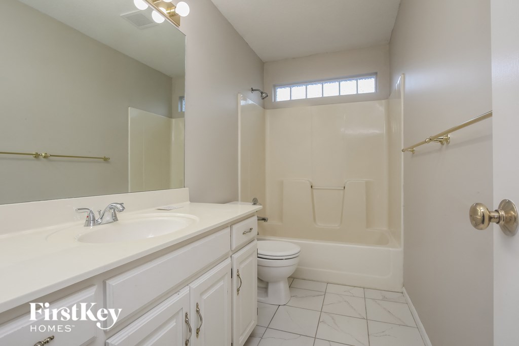 a white bathroom with a white sink and a toilet