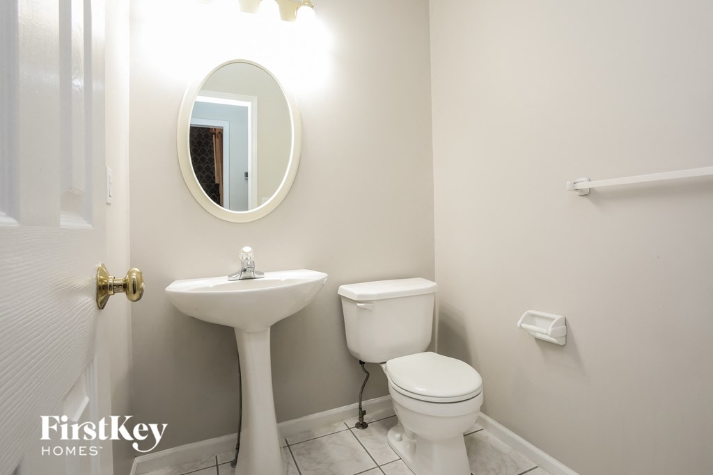 a white bathroom with a sink toilet and a mirror