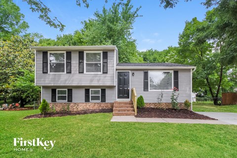 a home with a lawn and a sidewalk in front of it