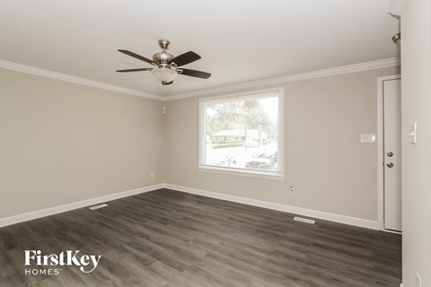 a living room with wood floors and a ceiling fan