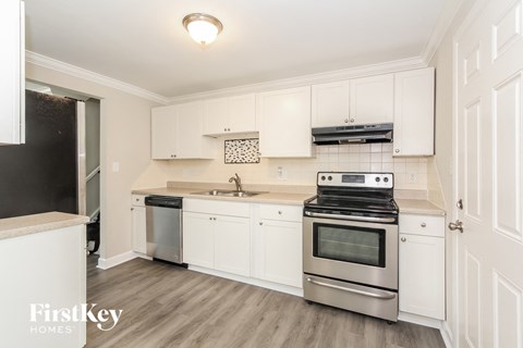 a kitchen with white cabinets and stainless steel appliances