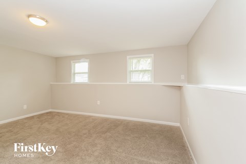 a bedroom with a carpeted floor and two windows
