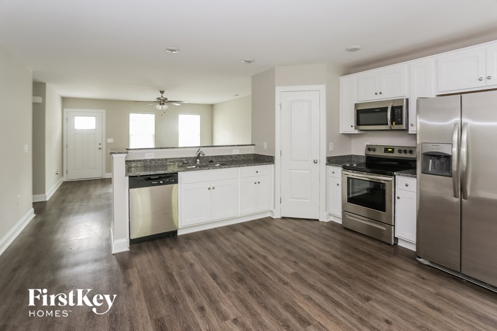 a kitchen with white cabinets and stainless steel appliances