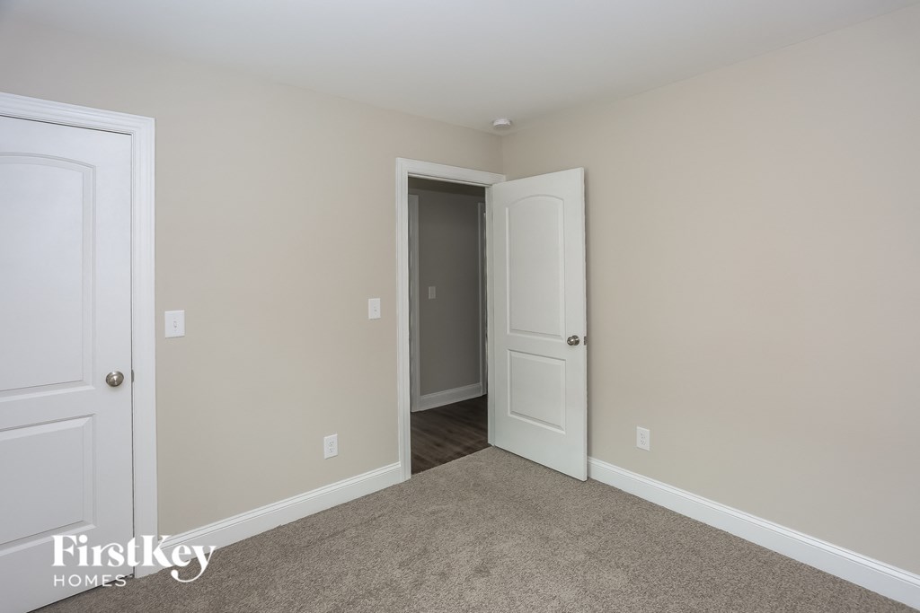a bedroom with two doors and a hallway to a closet