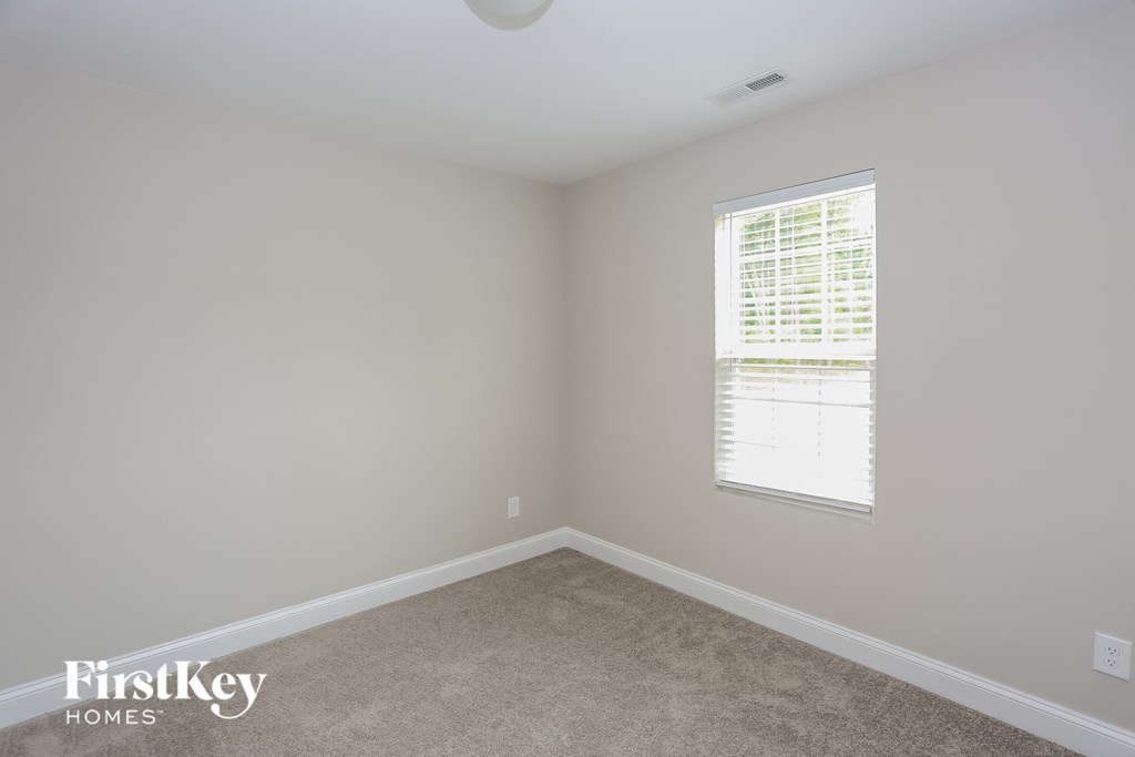 a bedroom with a carpeted floor and a window
