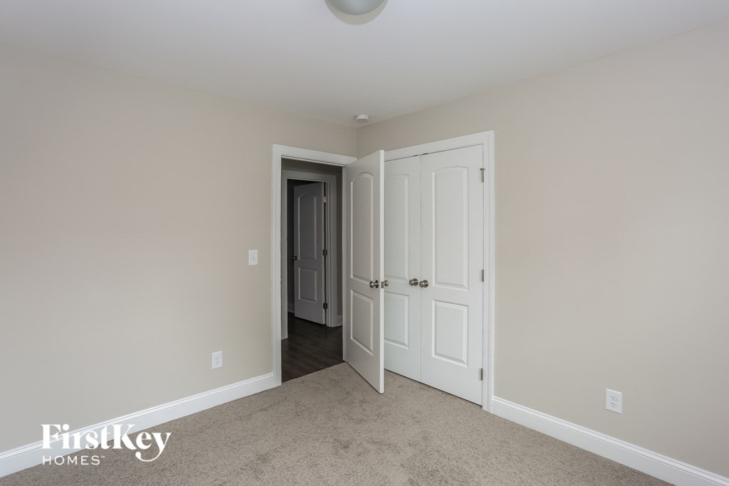 a bedroom with two closets and a door into a hallway