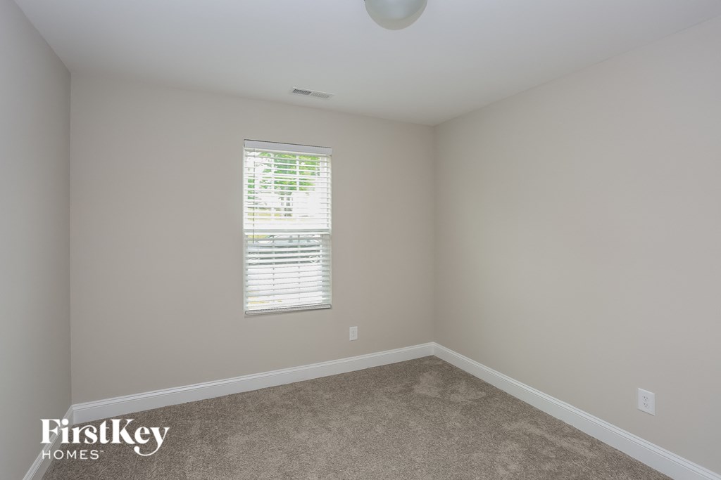 a bedroom with a carpeted floor and a window