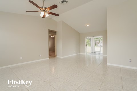 A spacious room with a ceiling fan and tiled flooring.