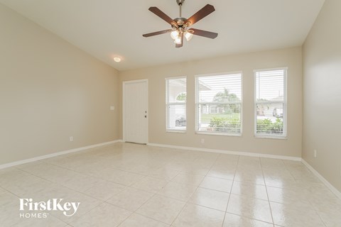 A spacious room with a ceiling fan and tiled floor.