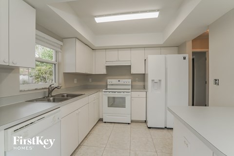 A kitchen with white cabinets and appliances.