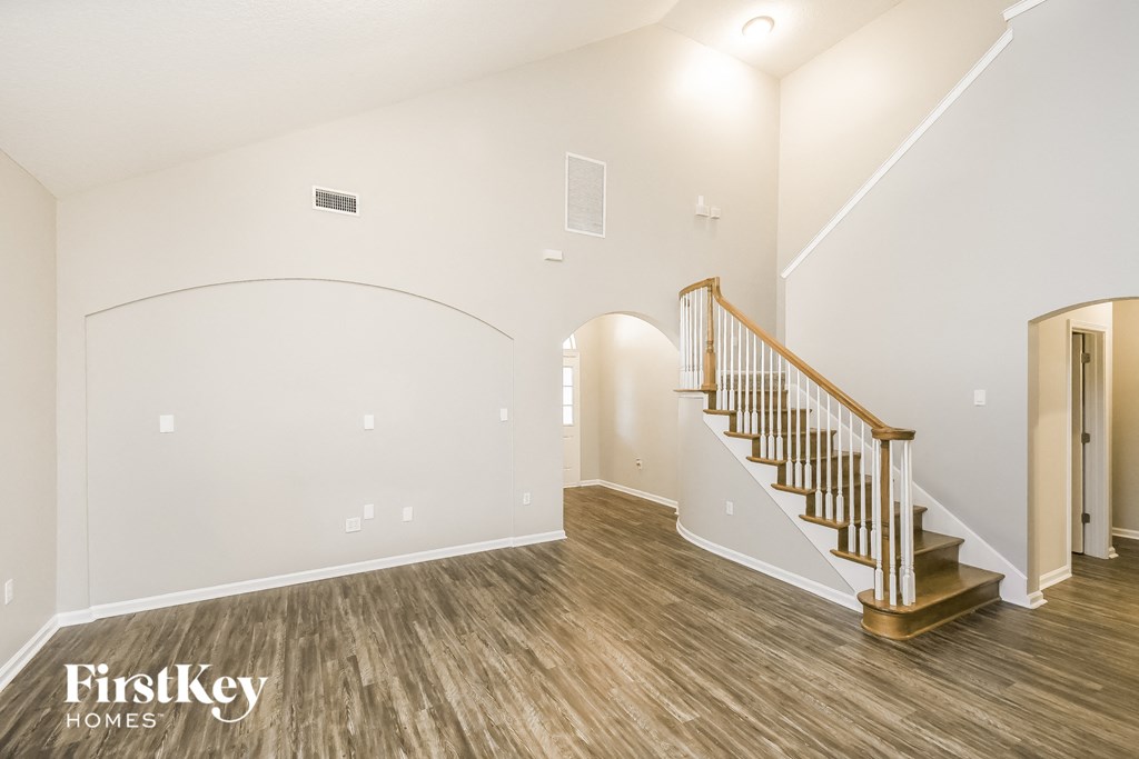 A spacious room with a staircase and a FirstKey Homes logo.